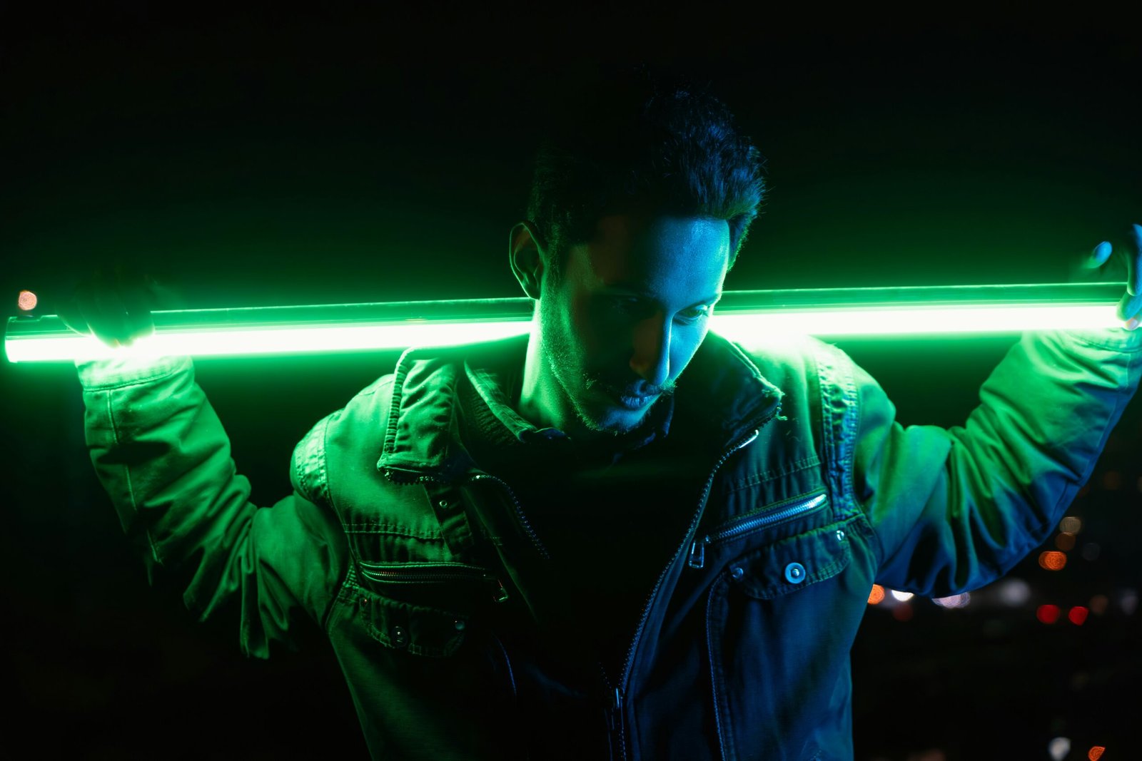 Man holds a glowing green light tube.