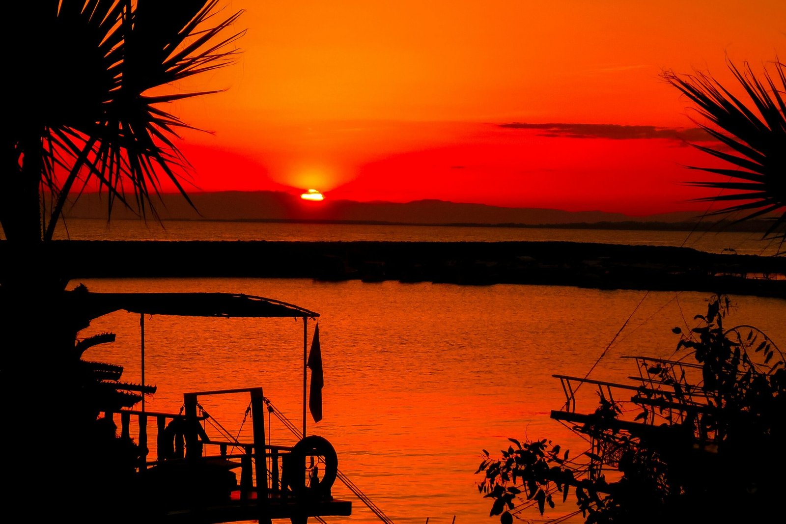 silhouette of people on boat on sea during sunset